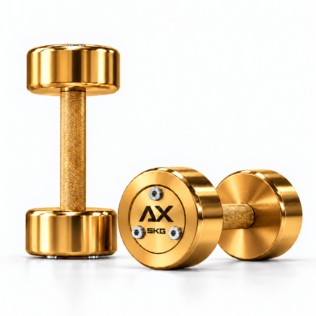 Axiom Strength Gold steel dumbbell pair with gold knurled handles, gold faceplates, silver bolts and black AX weight markings, shown as a 5kg pair on a white background.